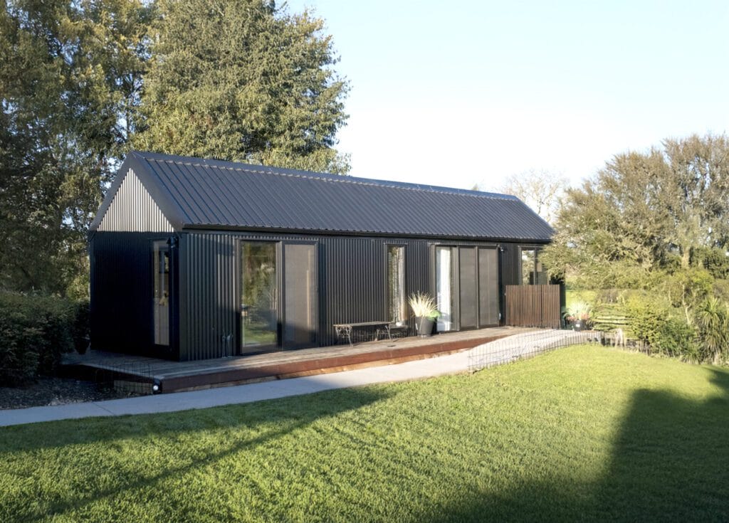 Everest XL 2 Bedroom Tiny Home by Fox Cabins with deck built onsite by client.