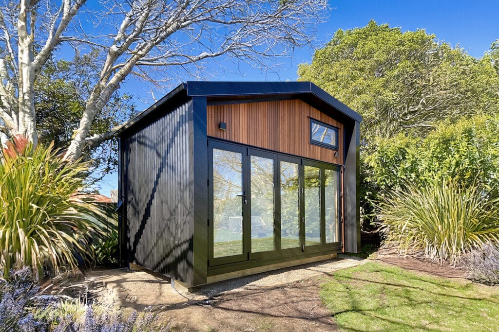 Fox Den Mezzanine Cabin by Fox Cabins, Raglan. Front wall in Hermpac Cedar with 4 Meter wide bifold doors.