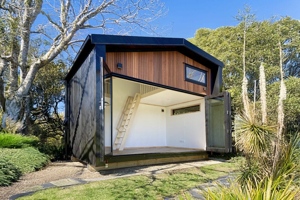Fox Den Mezzanine Cabin by Fox Cabins, Raglan. Front wall in Hermpac Cedar with 4 Meter wide bifold doors.