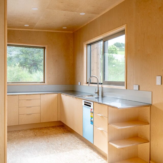 Kitchen design. 'The Bach' comes in One, Two and Three Bedroom designs. These Homes meet the 70m2 Granny Flat Regulations. Nordic Pine and Colorsteel Cladding. These prefabricated modular homes are built in Raglan. Shown in the photo is the 60m2 design, with 2 bedrooms.